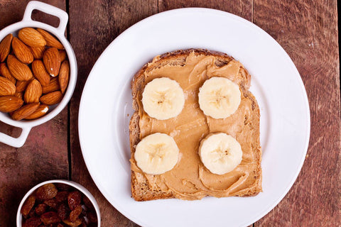 Banana and peanut butter toast with almonds and raisins